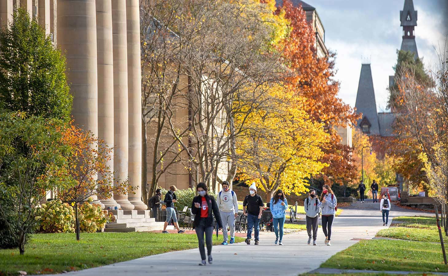 Masked students strolling to class in front of Goldwin Smith