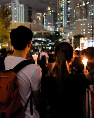 People stand with light candles